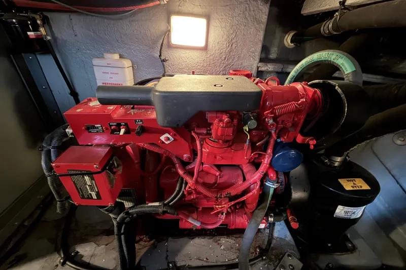 Slide: The Image of Engine room of a 2001 Sea Ray 380 Sundancer with red machinery and hoses. - 47