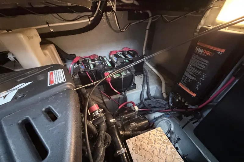 Slide: The Image of Engine compartment of a 2001 Sea Ray 380 Sundancer with batteries and wiring visible. - 54
