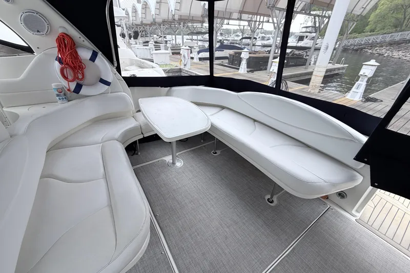 Slide: The Image of Interior of a 2001 Sea Ray 380 Sundancer with white seating and table. - 7