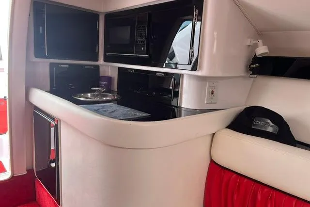 Slide: The Image of Interior of a 2000 Donzi 33 ZX boat featuring a compact kitchen area. - 14