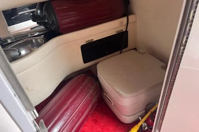 Slide: The Image of Interior of 2000 Donzi 33 ZX boat with compact amenities and red accents. - 16