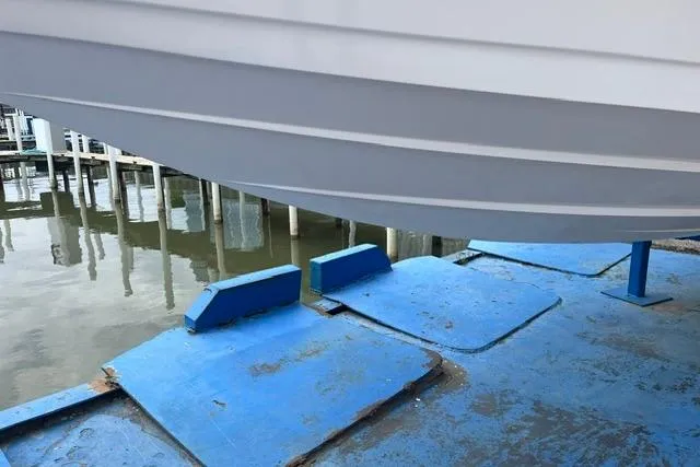 Slide: The Image of 2000 Donzi 33 ZX boat hull on blue dry dock near water. - 18