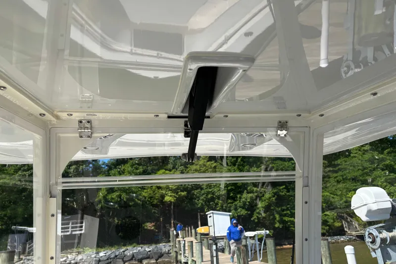Slide: The Image of 2023 Cobia 301 Center Console boat interior with dock view and lush greenery. - 10