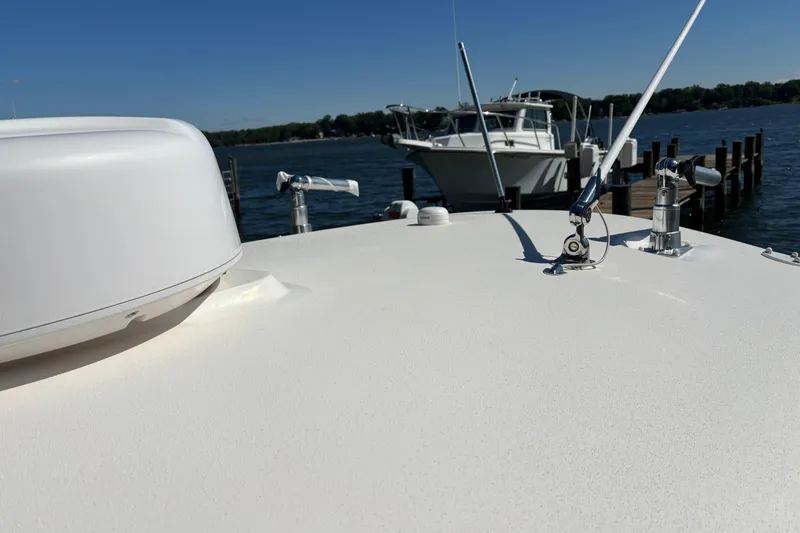 Slide: The Image of 2023 Cobia 301 Center Console boat docked by the water on a sunny day. - 11