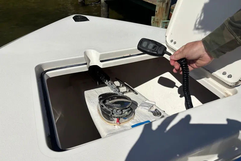 Slide: The Image of 2023 Cobia 301 Center Console anchor compartment with remote control in hand. - 12