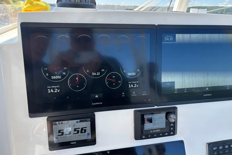 Slide: The Image of Dashboard of 2023 Cobia 301 Center Console with Garmin displays and JL Audio system. - 15