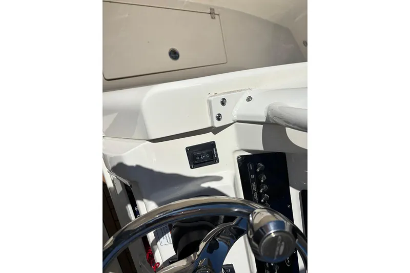 Slide: The Image of 2023 Cobia 301 Center Console helm with steering wheel and control panel. - 16