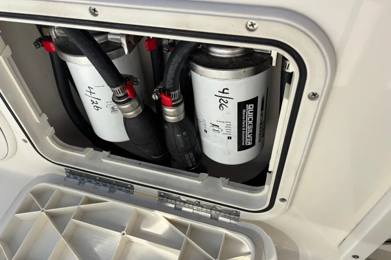 Slide: The Image of 2023 Cobia 301 Center Console fuel filters and hoses in compartment. - 18