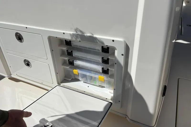 Slide: The Image of Storage compartment on 2023 Cobia 301 Center Console boat with organized tackle boxes. - 22