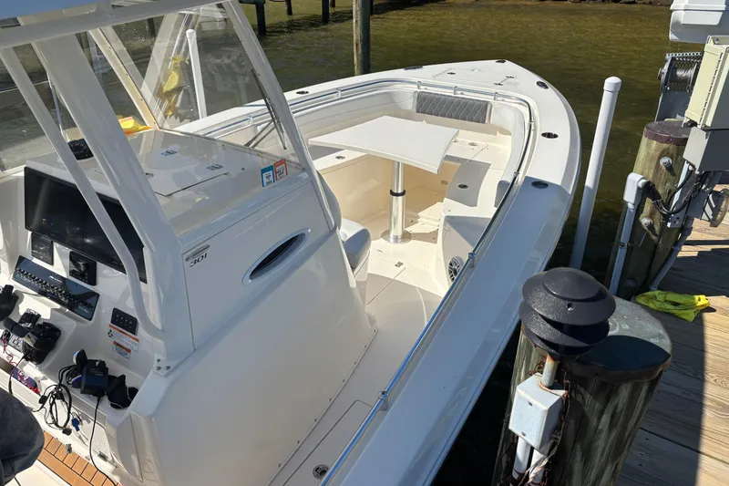 Slide: The Image of 2023 Cobia 301 Center Console boat docked, featuring spacious seating and modern controls. - 4