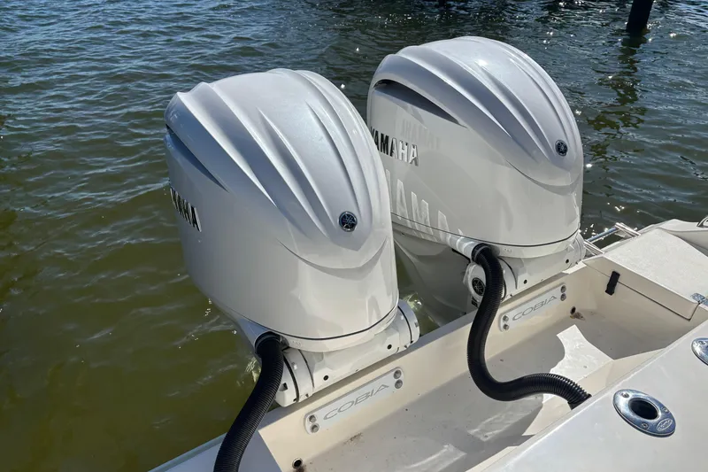 Slide: The Image of 2023 Cobia 301 Center Console with twin Yamaha outboard engines on water. - 5