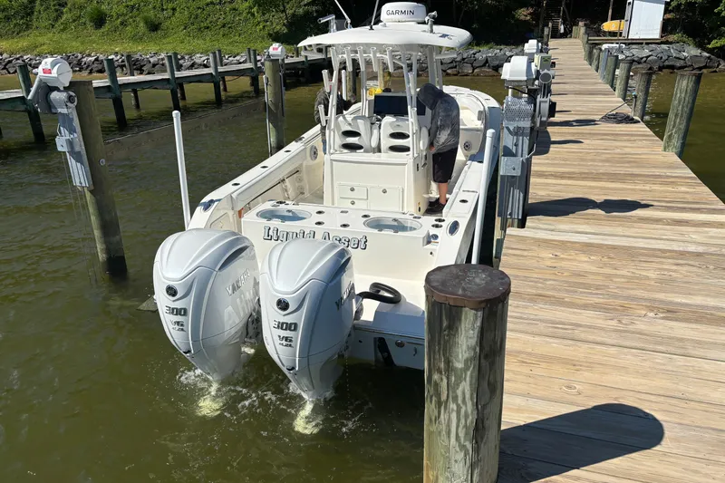 Slide: The Image of 2023 Cobia 301 Center Console boat docked with twin Yamaha engines. - 6