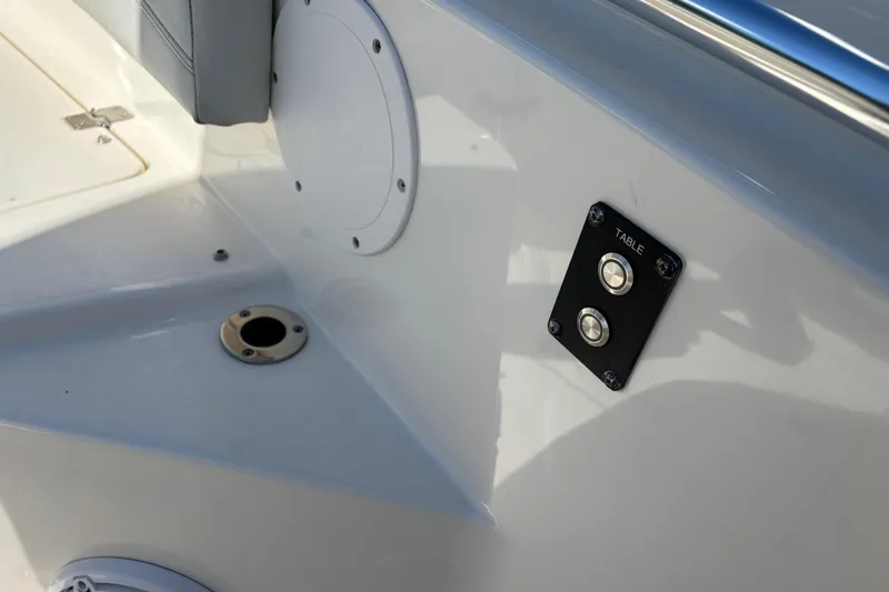 Slide: The Image of 2023 Cobia 301 Center Console boat interior with table control panel and seating area. - 7