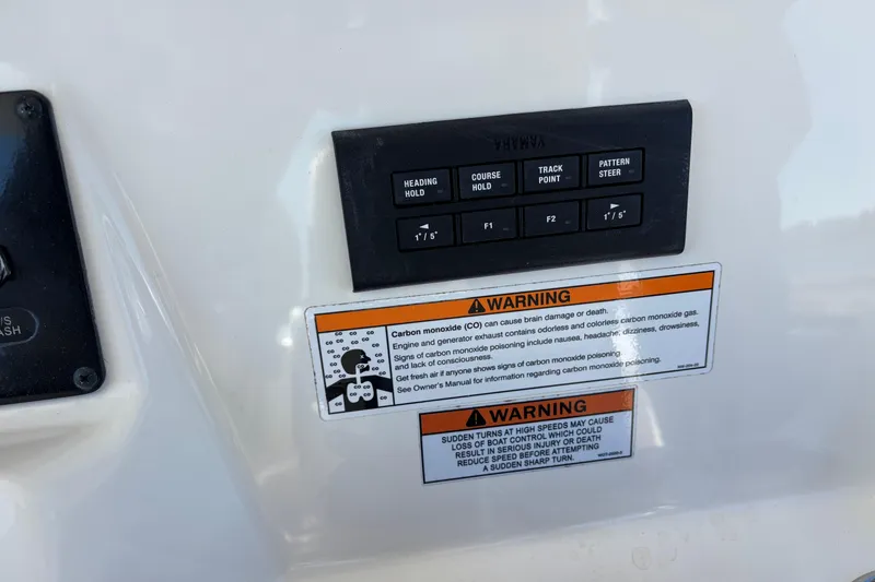 Slide: The Image of Control panel and warning labels on a 2023 Cobia 301 Center Console boat. - 8