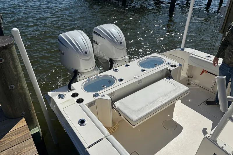 Slide: The Image of 2023 Cobia 301 Center Console boat with dual Yamaha outboard engines docked by water. - 9