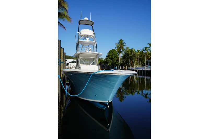 The Image of 2014 SeaHunter 45 Tournament boat docked by palm trees, reflecting on calm water. - 1