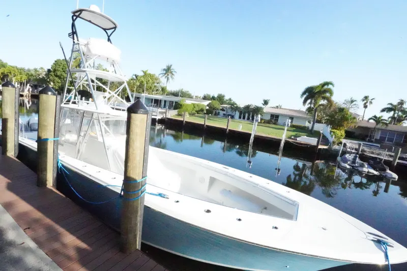 Slide: The Image of 2014 SeaHunter 45 Tournament boat docked by waterfront homes, clear sky, and palm trees. - 14
