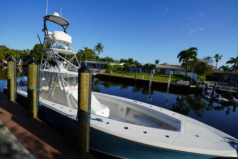 Slide: The Image of 2014 SeaHunter 45 Tournament boat docked by a serene waterfront with palm trees. - 15