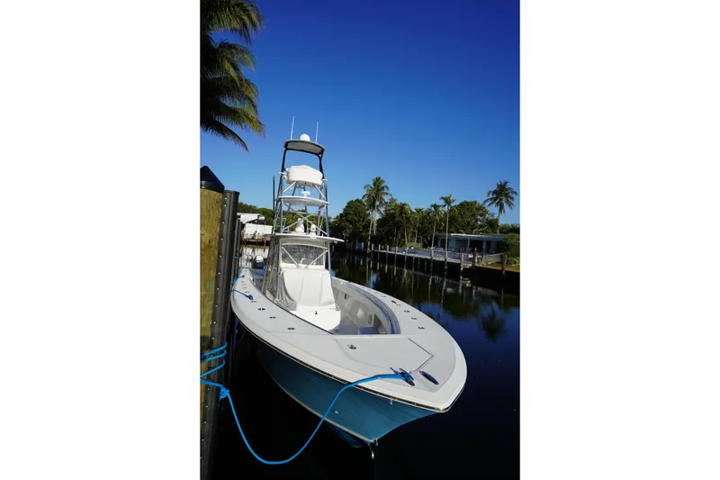 Slide: The Image of 2014 SeaHunter 45 Tournament boat docked by palm trees under clear blue sky. - 16