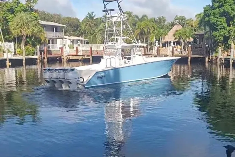 Slide: The Image of 2014 SeaHunter 45 Tournament boat on calm water, surrounded by lush greenery and waterfront homes. - 18