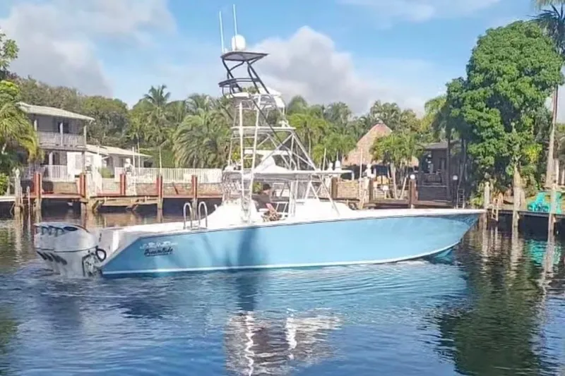 Slide: The Image of 2014 SeaHunter 45 Tournament boat on calm water near a dock, surrounded by trees. - 19