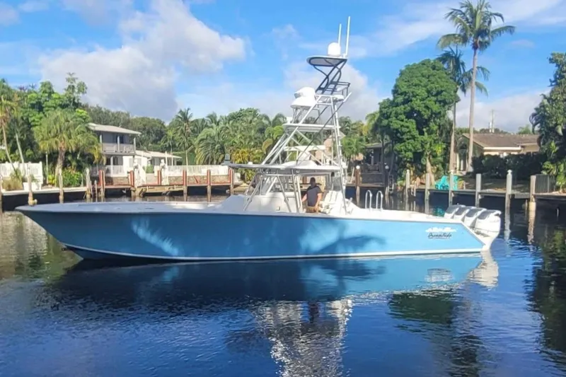 Slide: The Image of 2014 SeaHunter 45 Tournament boat on calm water, surrounded by lush greenery and waterfront homes. - 2
