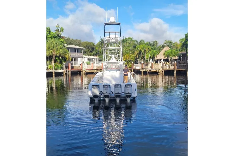 Slide: The Image of 2014 SeaHunter 45 Tournament boat with multiple engines docked in a scenic marina. - 24
