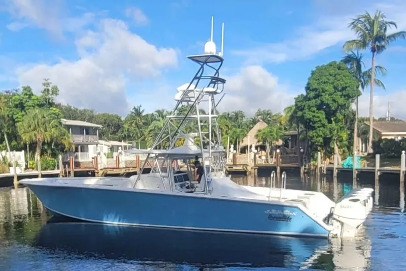 Slide: The Image of Blue 2014 SeaHunter 45 Tournament boat docked by tropical waterfront homes. - 25