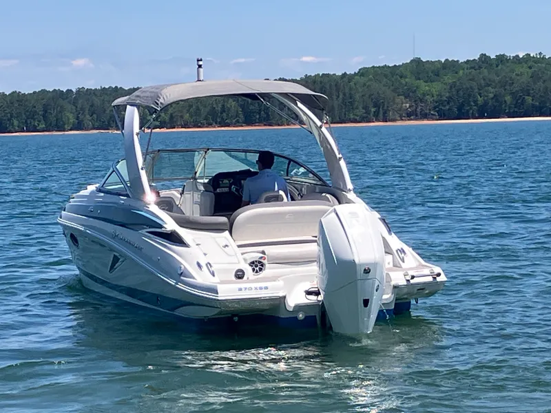 Slide: The Image of 2023 Crownline 270 XSS boat on a serene lake. - 9