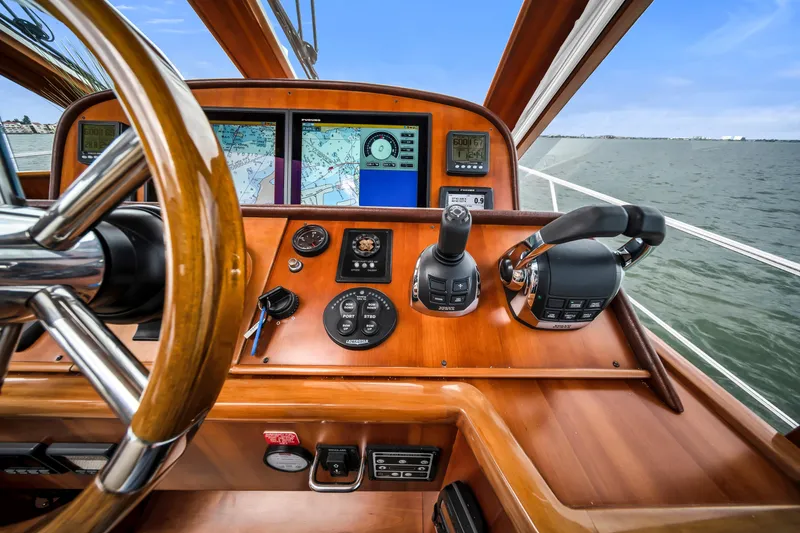 Slide: The Image of Helm of 2011 Hunt 52 yacht with navigation screens and controls on open water. - 14