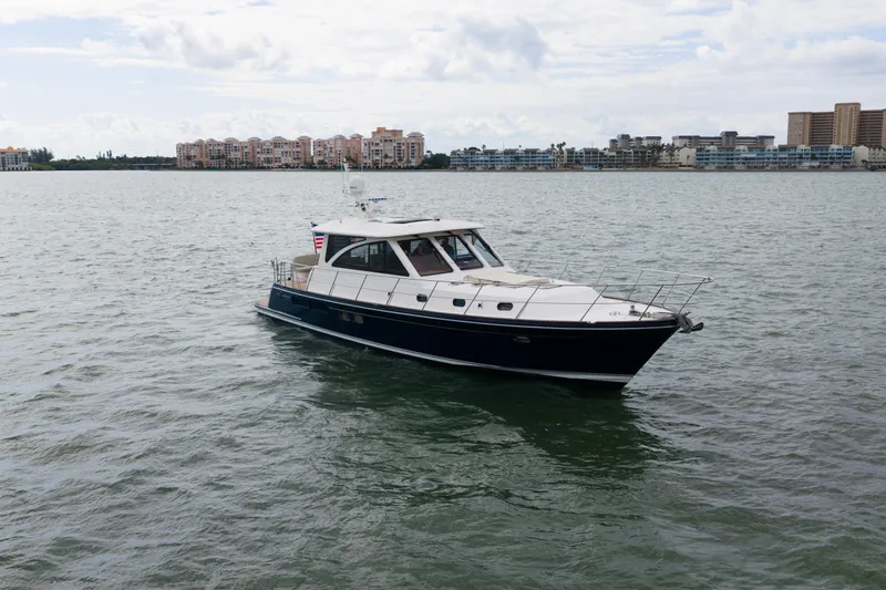 Slide: The Image of 2011 Hunt 52 yacht cruising on calm waters near coastal buildings. - 4