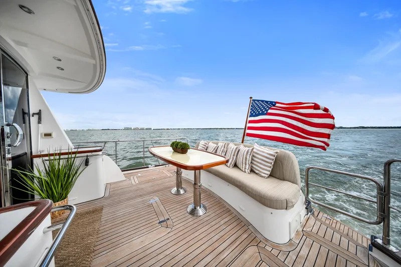 Slide: The Image of Luxury yacht Hunt 52 deck with American flag, ocean view, and elegant seating, 2011 model. - 8