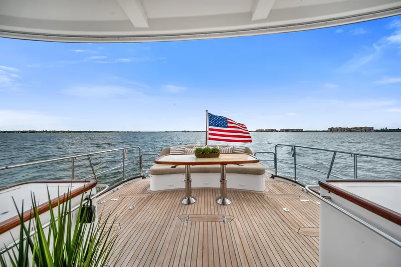 Slide: The Image of Luxury yacht deck with American flag, ocean view, and elegant seating on Hunt 52, 2011 model. - 9