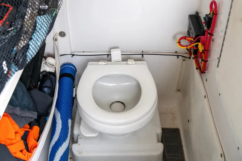 Slide: The Image of 2014 Sea Hunt Gamefish 27 boat interior with toilet and storage area. - 10