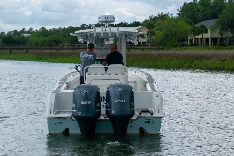 Slide: The Image of 2014 Sea Hunt Gamefish 27 boat with dual Yamaha engines on a scenic waterway. - 13