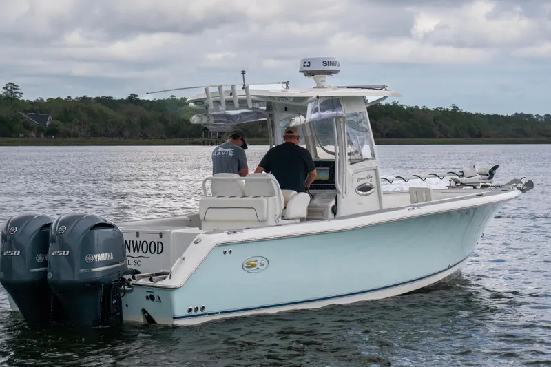 Slide: The Image of 2014 Sea Hunt Gamefish 27 boat with dual Yamaha engines on a calm waterway. - 15