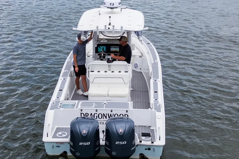 Slide: The Image of 2014 Sea Hunt Gamefish 27 boat on water, two people onboard, twin Yamaha 250 engines. - 17
