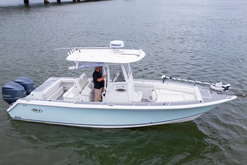 Slide: The Image of 2014 Sea Hunt Gamefish 27 boat on water, featuring dual engines and spacious deck. - 3