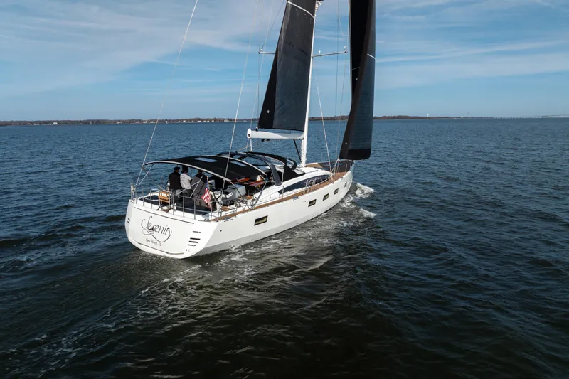 Slide: The Image of 2016 Jeanneau 64 yacht sailing on open water under clear skies. - 2