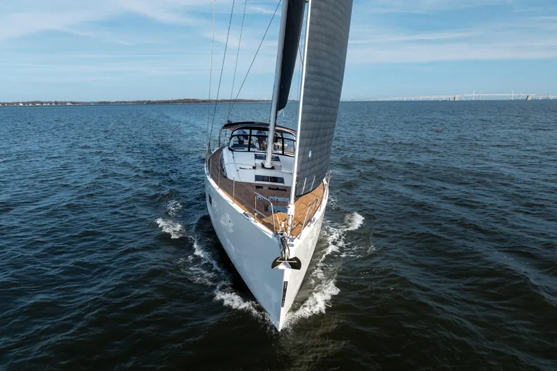 Slide: The Image of 2016 Jeanneau 64 yacht sailing on open water under clear skies. - 8