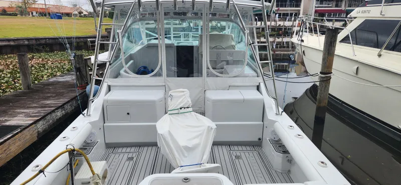 Slide: The Image of 1995 Cabo 35 Express boat docked, featuring spacious deck and covered seating area. - 18