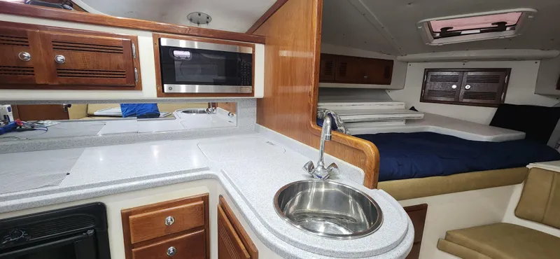 Slide: The Image of Interior of 1995 Cabo 35 Express boat with kitchenette and sleeping area. - 25