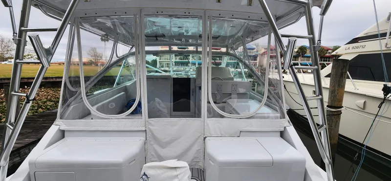 Slide: The Image of 1995 Cabo 35 Express boat docked, featuring enclosed cockpit and seating area. - 46