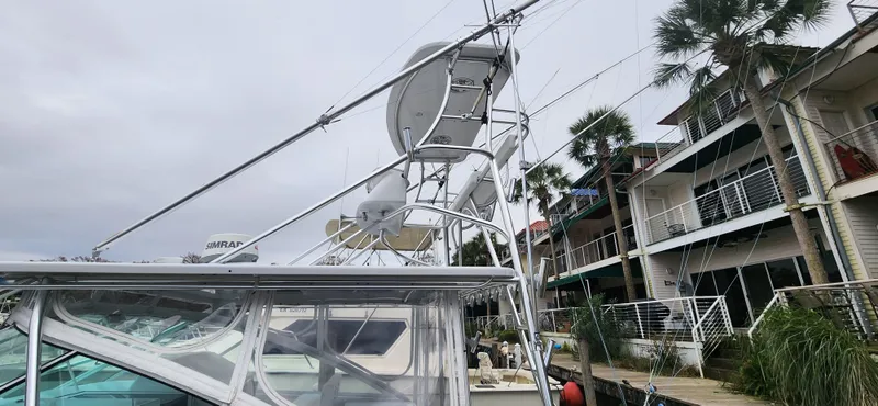Slide: The Image of 1995 Cabo 35 Express boat docked near waterfront homes, featuring radar and antennas. - 53