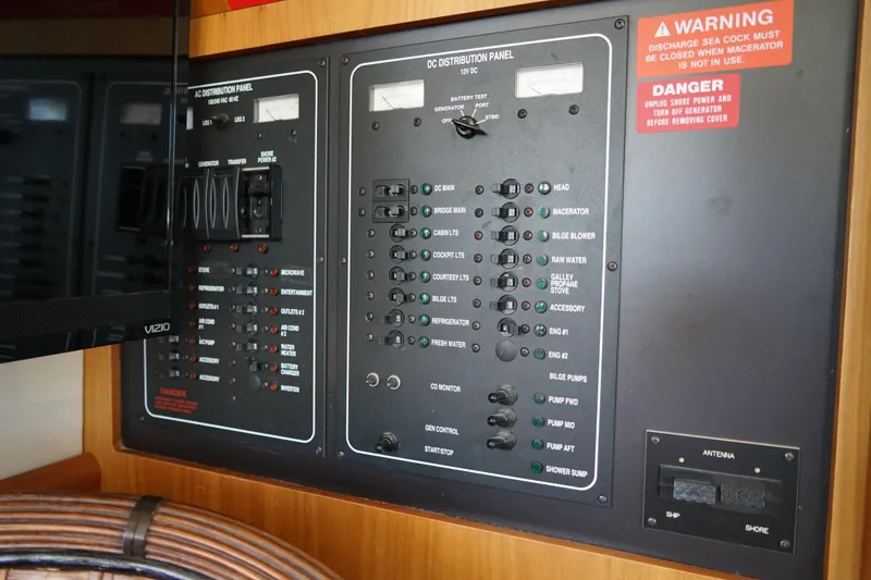 Slide: The Image of Electrical control panel on a Mainship boat with various switches and warning labels. - 13