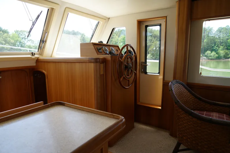 Slide: The Image of Interior of a Mainship boat featuring a wooden helm and wicker chair. - 14