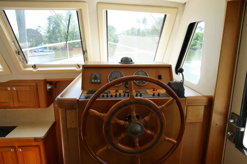 Slide: The Image of Mainship boat helm with wooden steering wheel and navigation instruments. - 15
