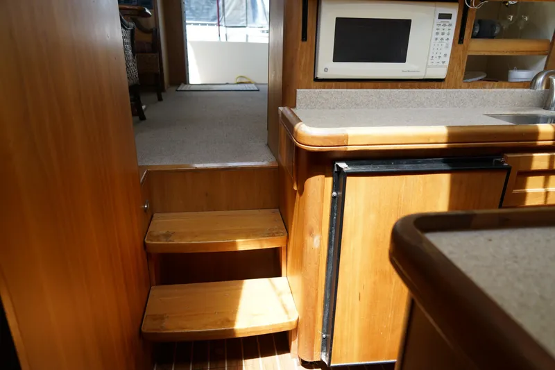 Slide: The Image of Interior of a Mainship boat featuring wooden steps, kitchenette, and microwave. - 19