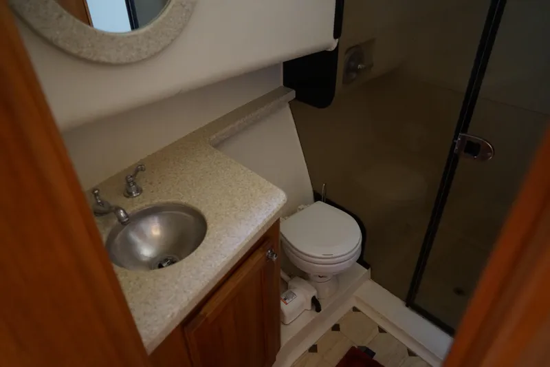 Slide: The Image of Mainship boat bathroom with sink, toilet, and shower; compact and functional design. - 24