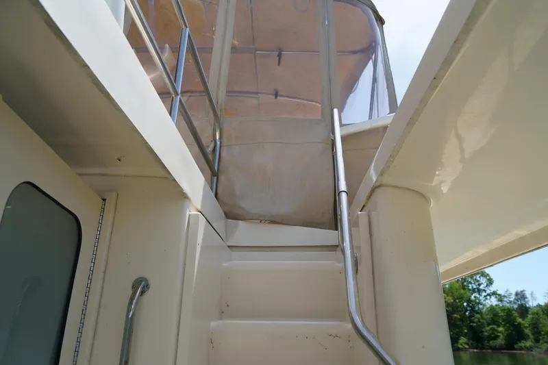 Slide: The Image of Staircase leading to the upper deck of a Mainship boat with canopy. - 26